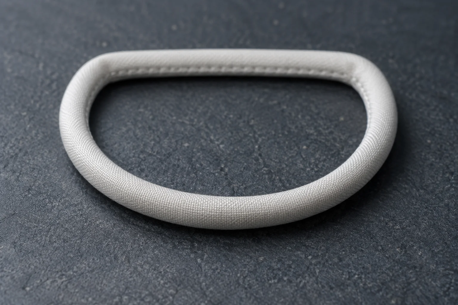 White textile covering following a D-shaped ring with an inner seam